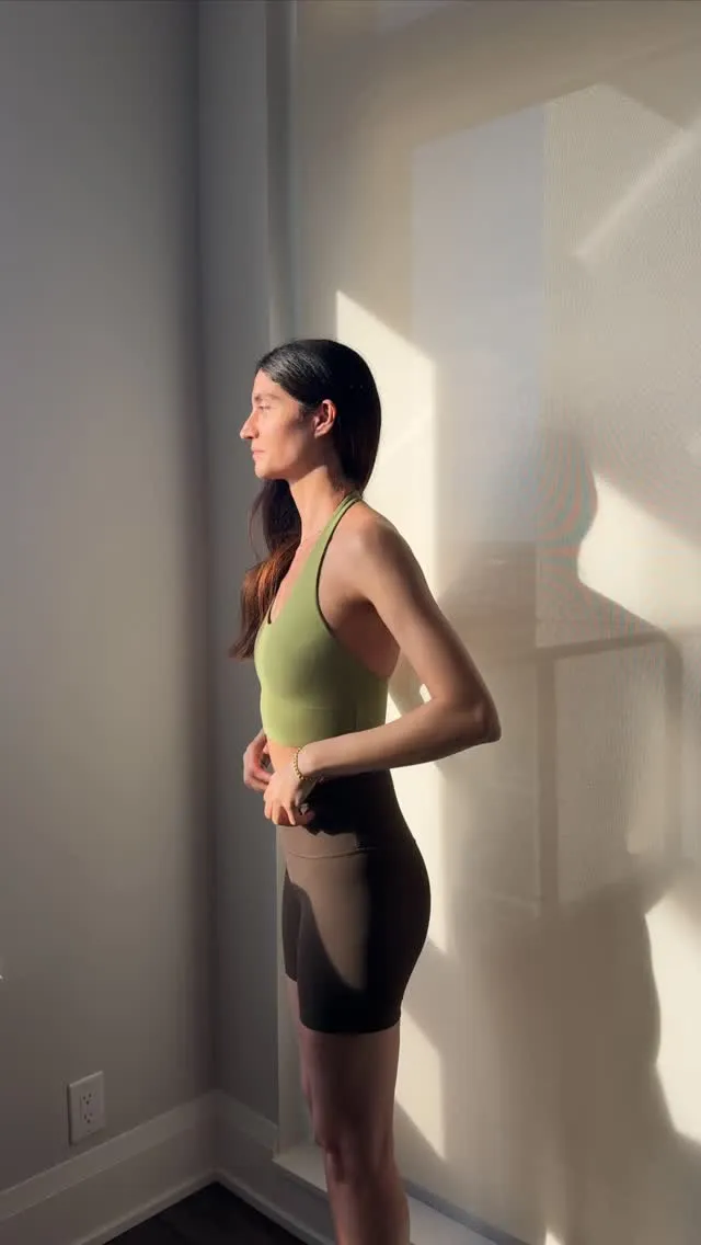 Toktam standing beside a sunlit wall